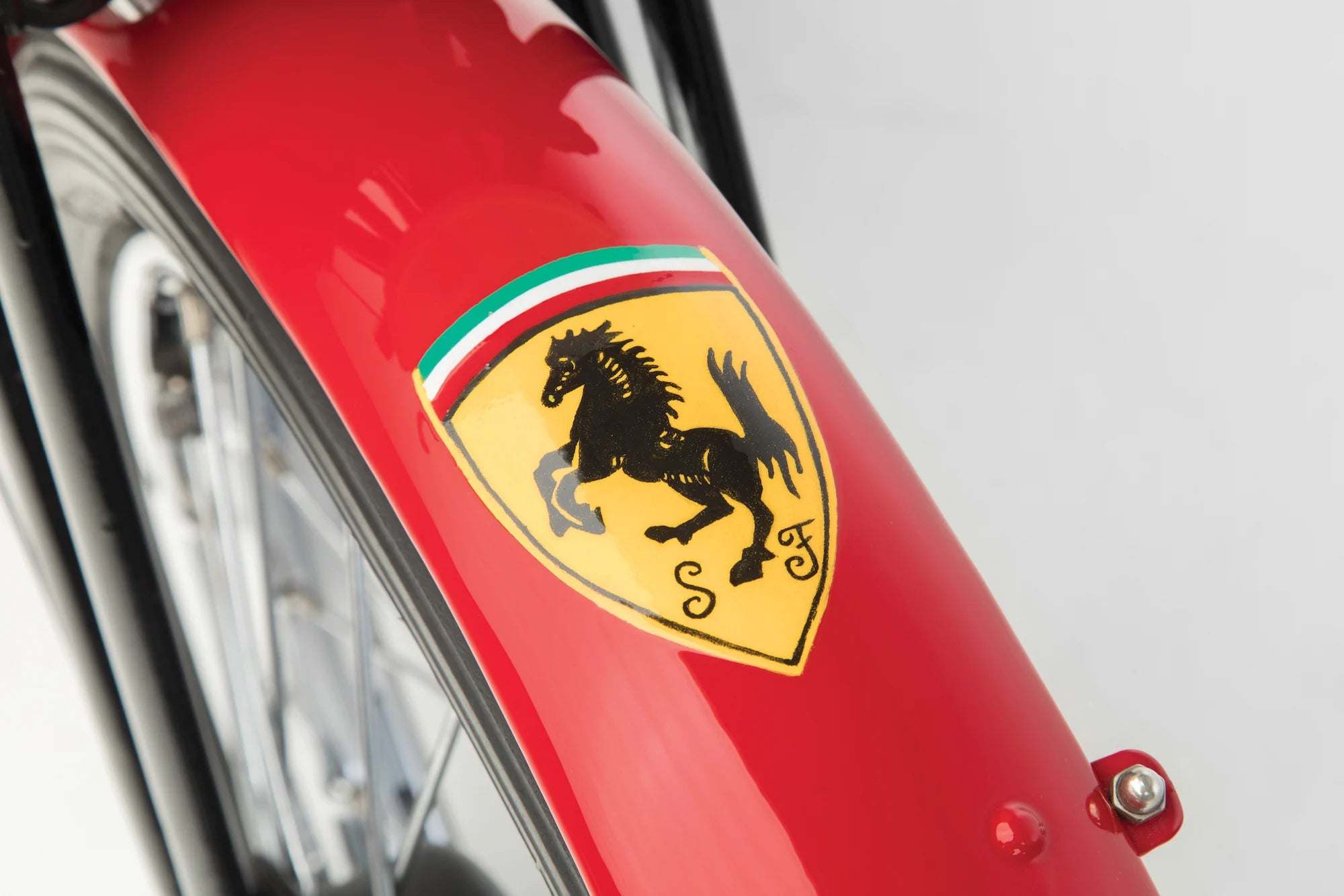 Close-up of a Ferrari logo on a red vehicle.